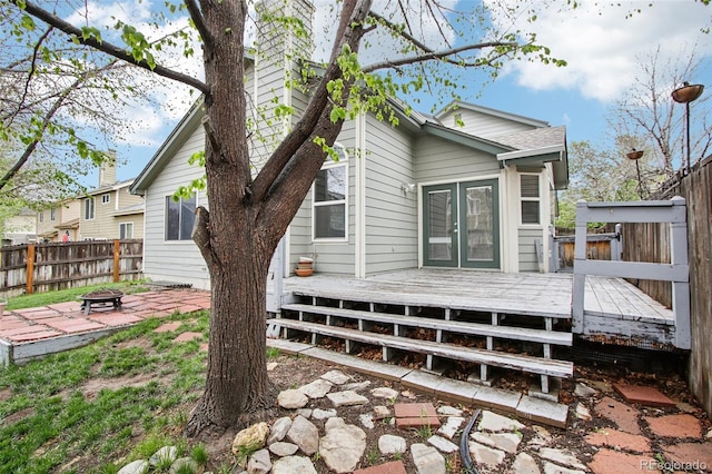17943 E Bates Ave, Aurora, CO 80013 - rear view of house featuring an outdoor fire pit, a wooden deck, and fence