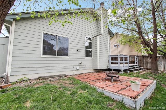 17943 E Bates Ave, Aurora, CO 80013 - back of house featuring an outdoor fire pit, a patio, a chimney, and fence