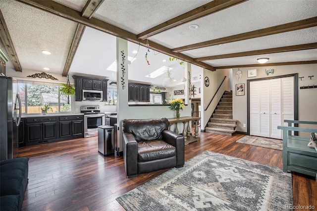 living room featuring stairs, a textured ceiling, and dark wood finished floors