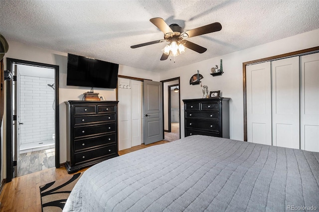 bedroom with connected bathroom, a textured ceiling, light wood finished floors, and multiple closets