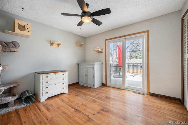 bedroom with a textured ceiling, access to exterior, baseboards, light wood-type flooring, and visible vents