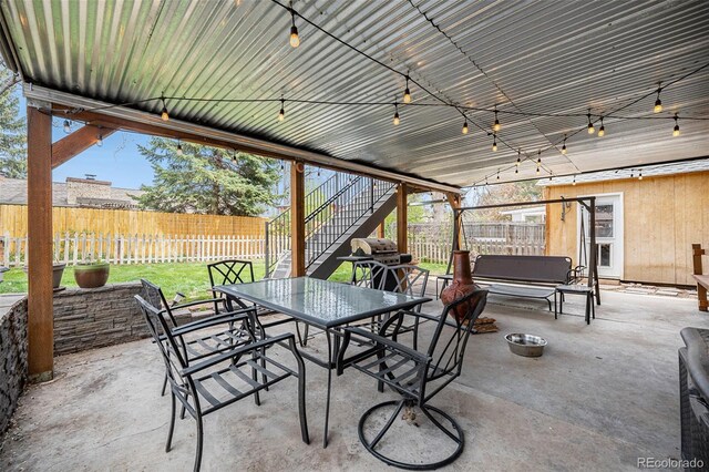 view of patio / terrace featuring a fenced backyard, outdoor dining space, stairs, and area for grilling
