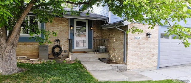 12175 W 68th Pl, Arvada, CO 80004 - view of exterior entry featuring a garage, brick siding, and a shingled roof
