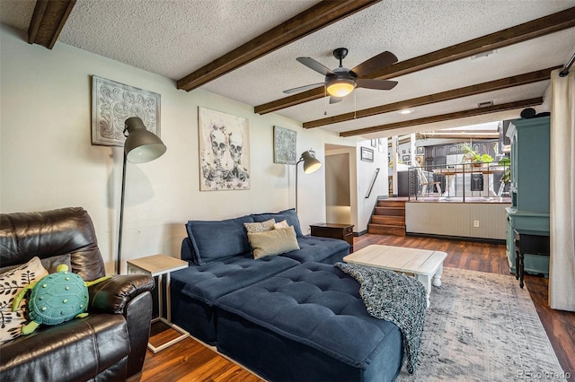 12175 W 68th Pl, Arvada, CO 80004 - living room with beam ceiling, a textured ceiling, a ceiling fan, stairway, and wood finished floors