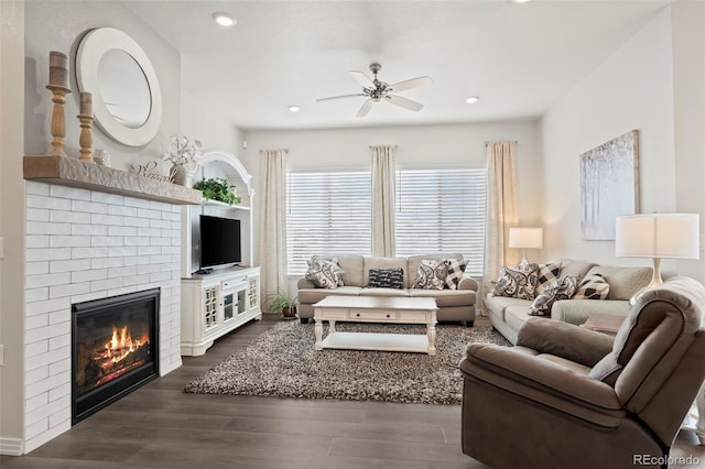 living room with ceiling fan, dark wood-type flooring, and a fireplace