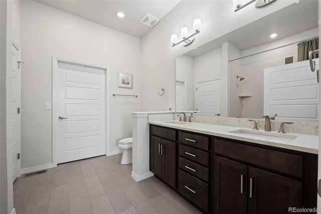 bathroom featuring vanity, a shower, and toilet