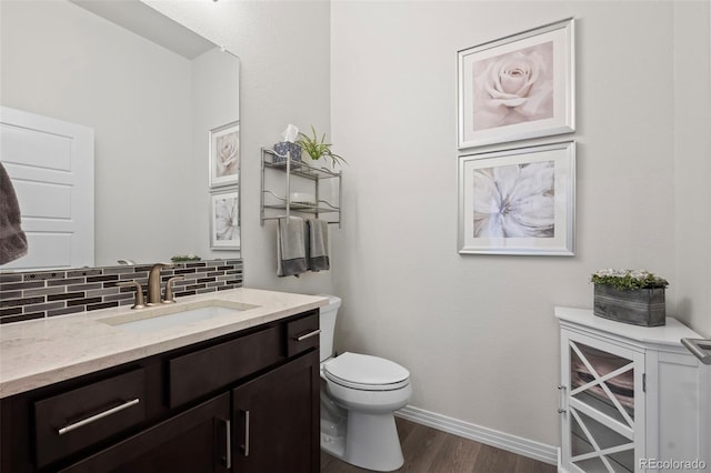 bathroom featuring vanity, backsplash, wood-type flooring, and toilet