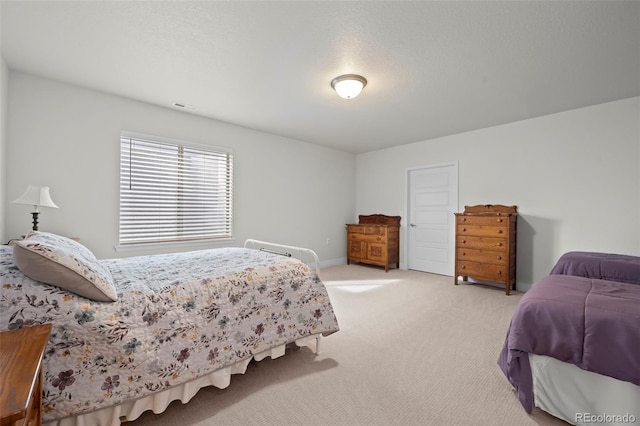 bedroom featuring light carpet and a textured ceiling