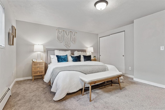 bedroom with baseboard heating, a closet, and carpet