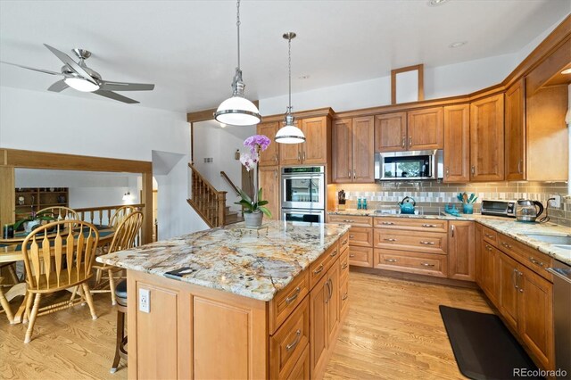 11131 Seton Pl, Westminster, CO 80031 - kitchen with stainless steel appliances, decorative backsplash, light stone countertops, a kitchen island, and decorative light fixtures