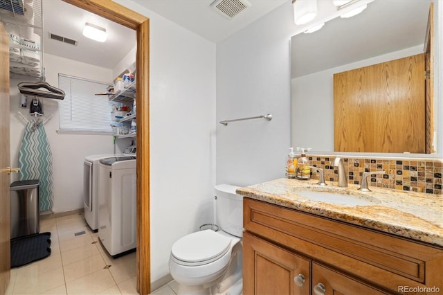 11131 Seton Pl, Westminster, CO 80031 - bathroom featuring washer and clothes dryer, toilet, tile patterned flooring, decorative backsplash, and vanity