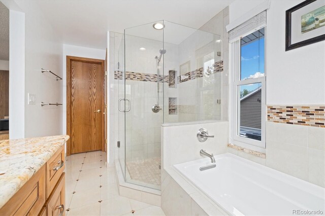 11131 Seton Pl, Westminster, CO 80031 - full bathroom featuring a shower stall, a bath, tile patterned floors, vanity, and tile walls
