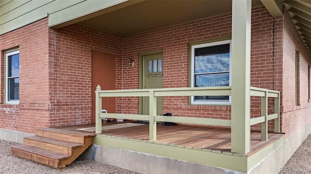 property entrance with brick siding and covered porch