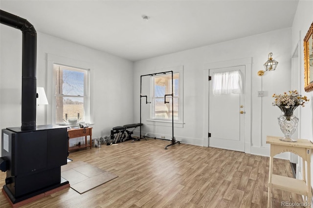 foyer featuring light wood-style flooring and a wood stove