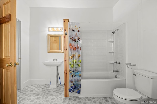 bathroom with baseboards, shower / tub combo, and toilet