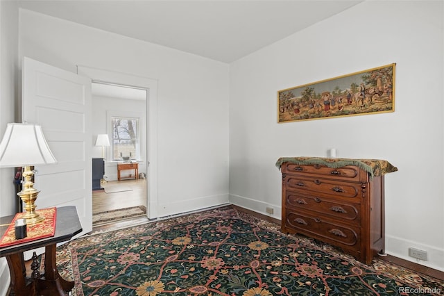 living area with baseboards and wood finished floors