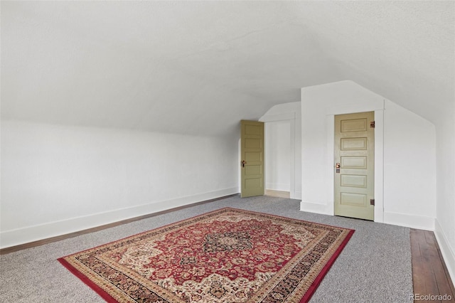 additional living space with baseboards and lofted ceiling