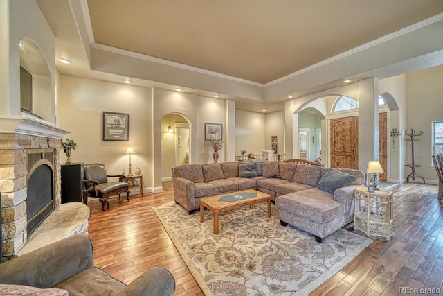 living room with a fireplace, wood-type flooring, and ornamental molding