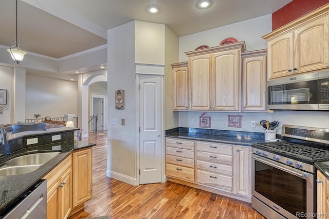 kitchen with light brown cabinetry, stainless steel appliances, crown molding, sink, and hanging light fixtures