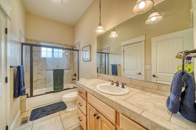 full bathroom featuring tile patterned flooring, vanity, toilet, and bath / shower combo with glass door