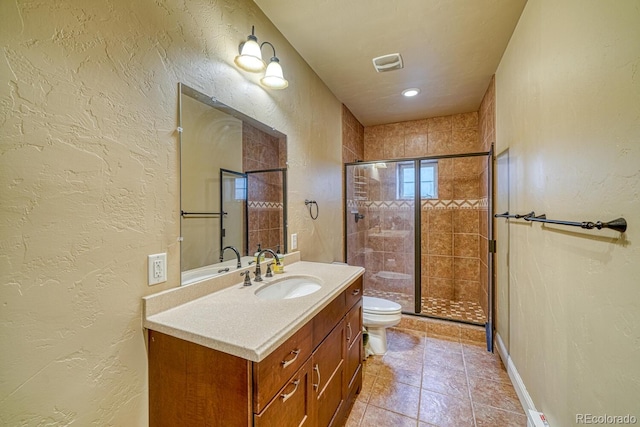 bathroom with tile patterned flooring, vanity, an enclosed shower, and toilet