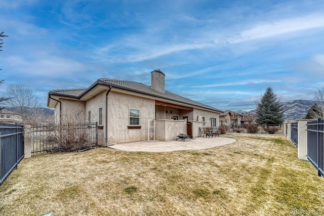 back of property with a patio area and a lawn