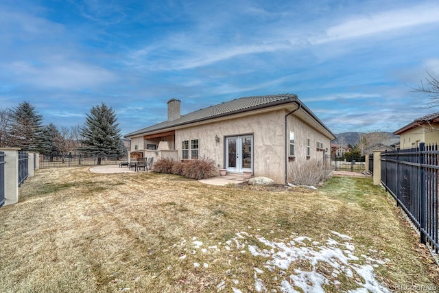 rear view of property with a yard, a patio, and french doors