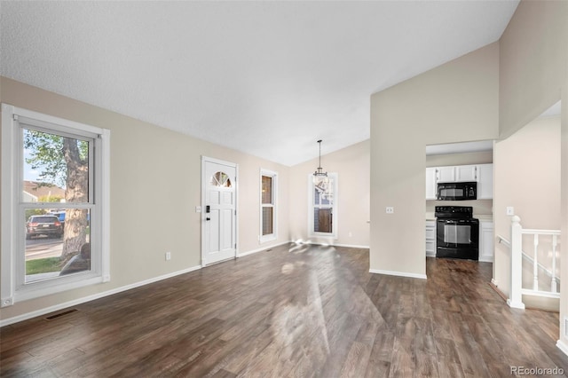 12665 Grove Ct, Broomfield, CO 80020 - unfurnished living room featuring vaulted ceiling, dark wood finished floors, and a chandelier