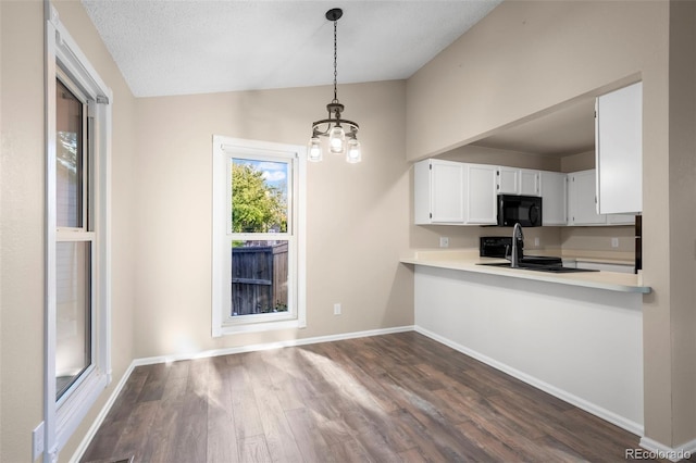 12665 Grove Ct, Broomfield, CO 80020 - kitchen with black microwave, vaulted ceiling, stove, dark wood-style flooring, and light countertops