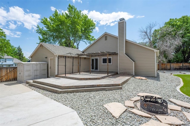 12665 Grove Ct, Broomfield, CO 80020 - back of property with an outdoor fire pit, a fenced backyard, a wooden deck, a pergola, and a chimney