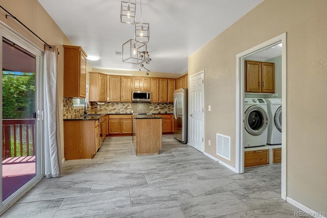 2452 S Andes Cir, Aurora, CO 80013 - kitchen with stainless steel appliances, washer and dryer, tasteful backsplash, light marble finish flooring, and dark countertops