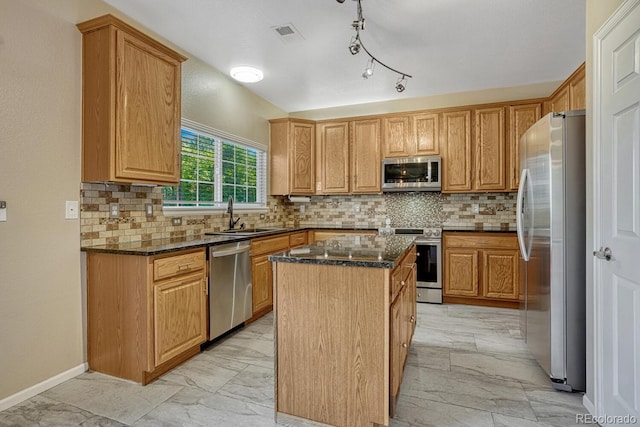 2452 S Andes Cir, Aurora, CO 80013 - kitchen featuring appliances with stainless steel finishes, light marble finish flooring, a kitchen island, dark stone counters, and tasteful backsplash