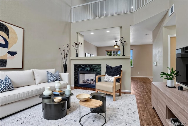 2452 S Andes Cir, Aurora, CO 80013 - living area with a towering ceiling, wood finished floors, recessed lighting, and a premium fireplace