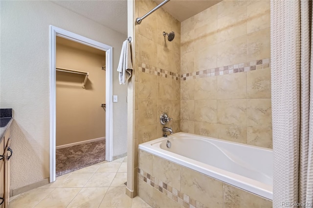 6727 W Yale Ave, Lakewood, CO 80227 - bathroom featuring tiled shower / bath combo, tile patterned flooring, and a walk in closet