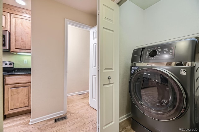 6727 W Yale Ave, Lakewood, CO 80227 - washroom featuring washer / dryer, light wood-type flooring, and baseboards