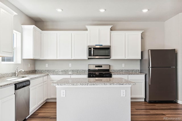 974 Cascade Falls St, Severance, CO 80550 - kitchen with stainless steel appliances, a center island, white cabinetry, dark wood-type flooring, and recessed lighting