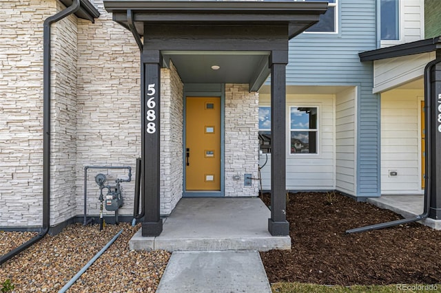 property entrance featuring stone siding