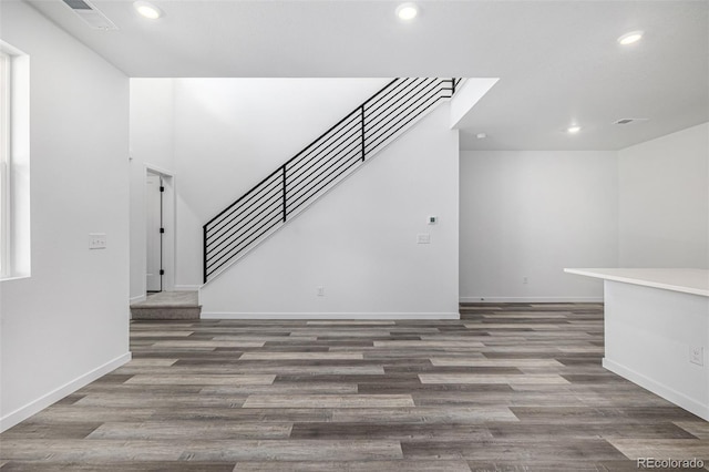 unfurnished living room featuring visible vents, wood finished floors, stairway, and recessed lighting