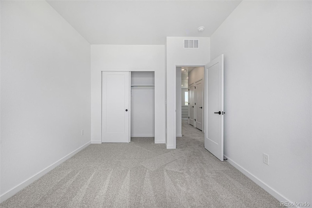 unfurnished bedroom with carpet floors, baseboards, visible vents, and a closet