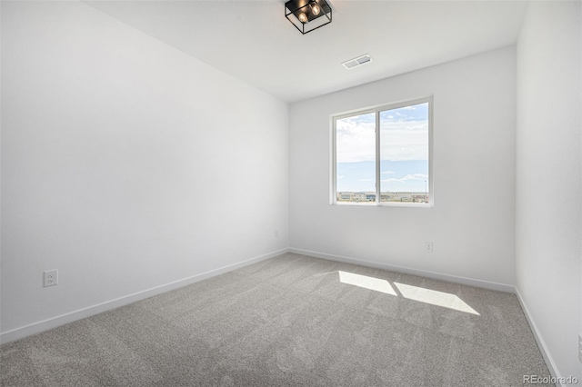 spare room with baseboards, carpet flooring, and visible vents
