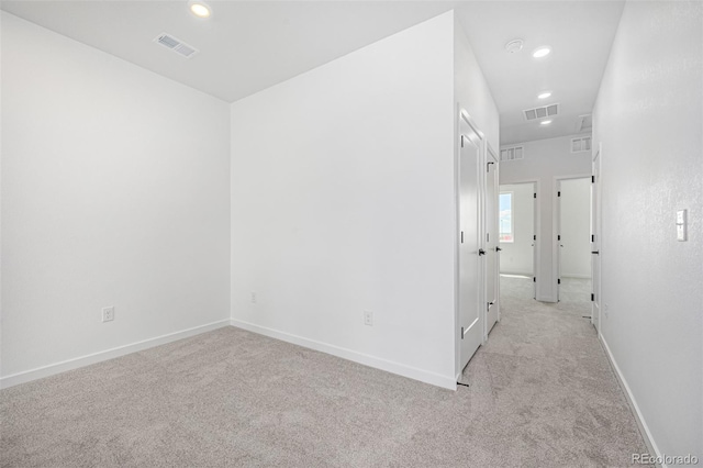 empty room featuring light colored carpet, visible vents, and recessed lighting