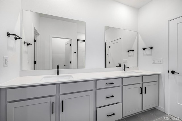 full bathroom featuring a sink, double vanity, and tile patterned flooring