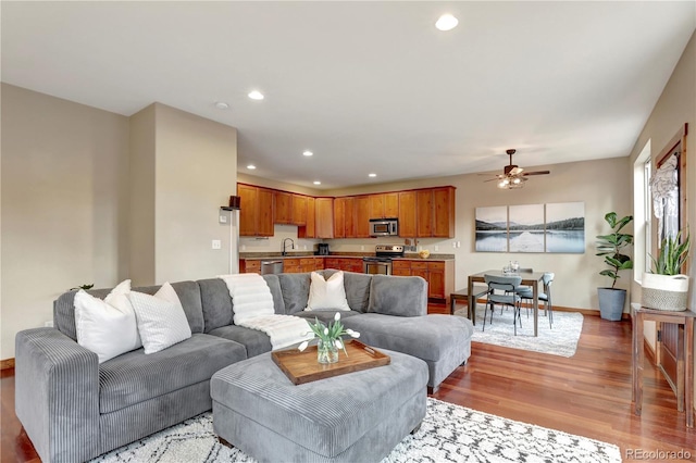 living area with recessed lighting, light wood-style flooring, baseboards, and ceiling fan