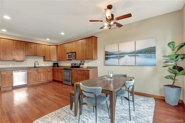 kitchen with ceiling fan, baseboards, recessed lighting, wood finished floors, and stainless steel appliances