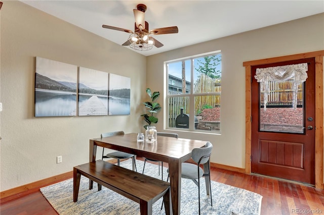 dining space featuring a ceiling fan, baseboards, and wood finished floors