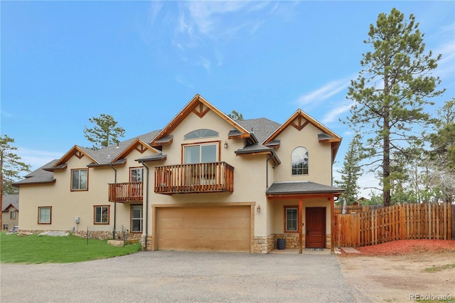 view of front of property with fence, stucco siding, a garage, a balcony, and driveway