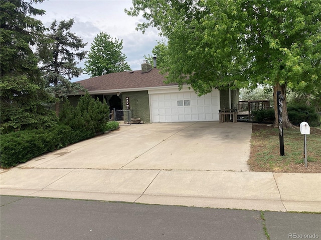 14751 E 24th Ave, Aurora, CO 80011 - view of front of property with an attached garage, concrete driveway, a chimney, and brick siding