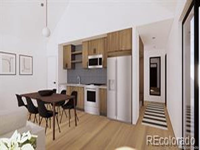 769 Turner St, Erie, CO 80516 - kitchen with white appliances, brown cabinets, backsplash, pendant lighting, and vaulted ceiling