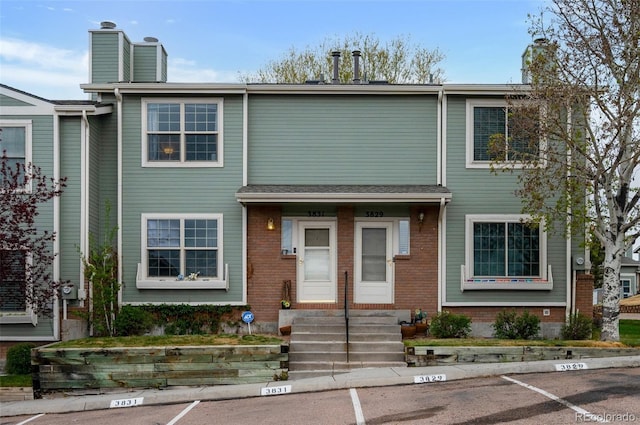 3831 Smoke Tree Dr, Colorado Springs, CO 80920 - multi unit property with uncovered parking, brick siding, a chimney, and entry steps