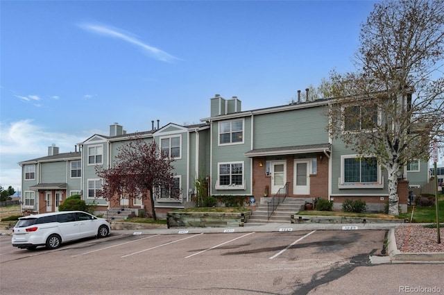 3831 Smoke Tree Dr, Colorado Springs, CO 80920 - view of property featuring brick siding, uncovered parking, and a chimney